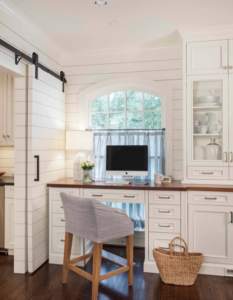 Home office with white built-in shelves and desk